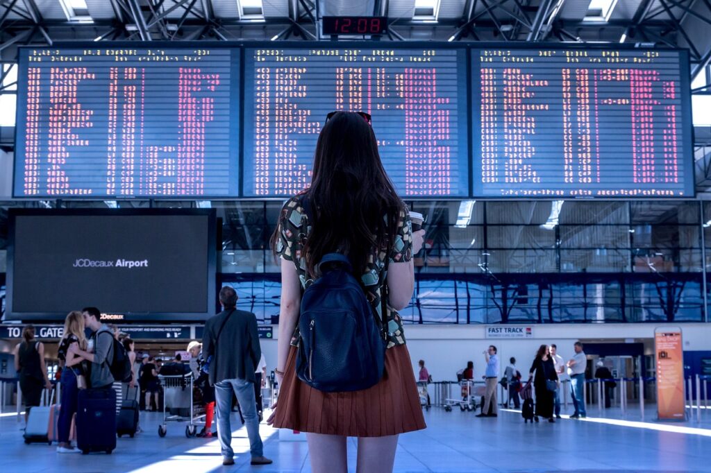 Un viaggiatore osserva il sistema di visualizzazione delle informazioni di volo in un aeroporto.